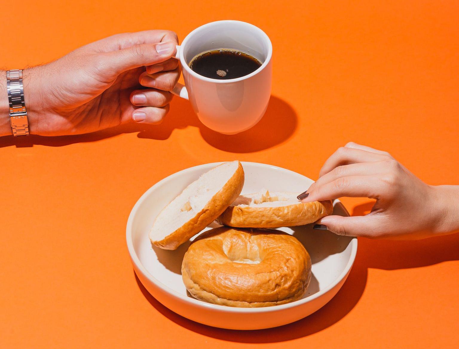 person holding white ceramic mug with brown liquid