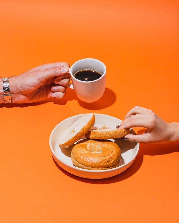 Beskrivning av bild. person holding white ceramic mug with brown liquid