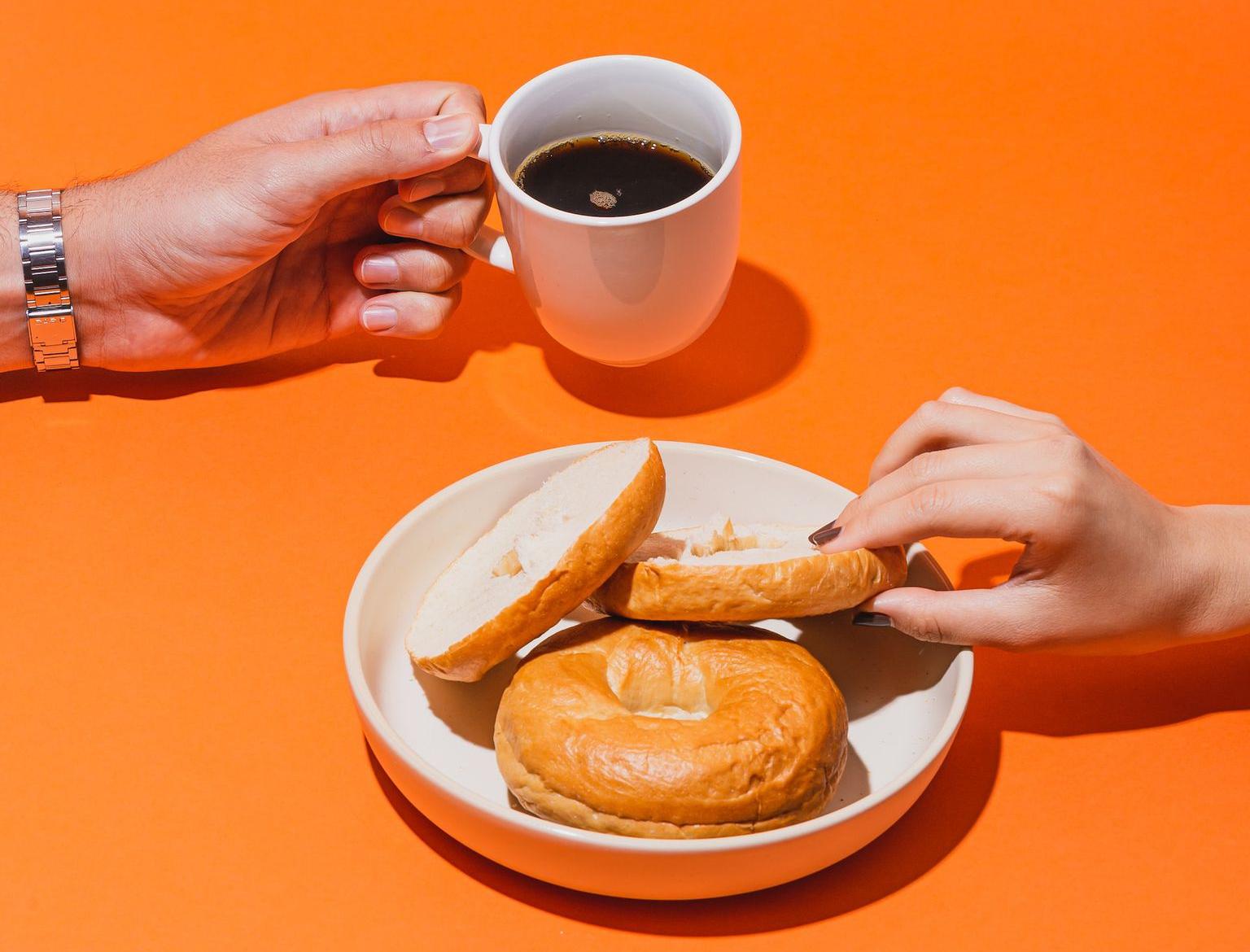 person holding white ceramic mug with brown liquid